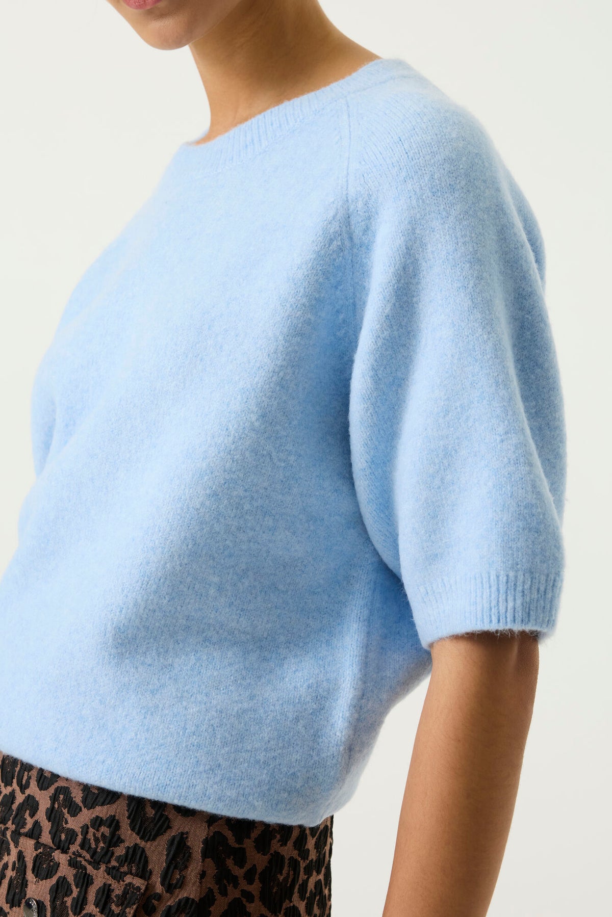 Pull bleu clair uni à col rond et manches courtes avec bordures côtelées