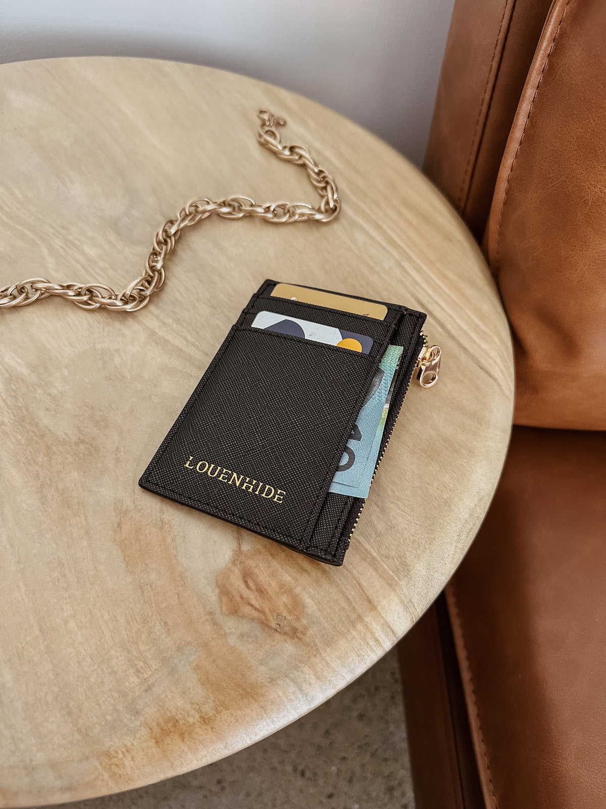 Porte-cartes Cara noir texturé avec fentes à cartes et fermeture zippée dorée.