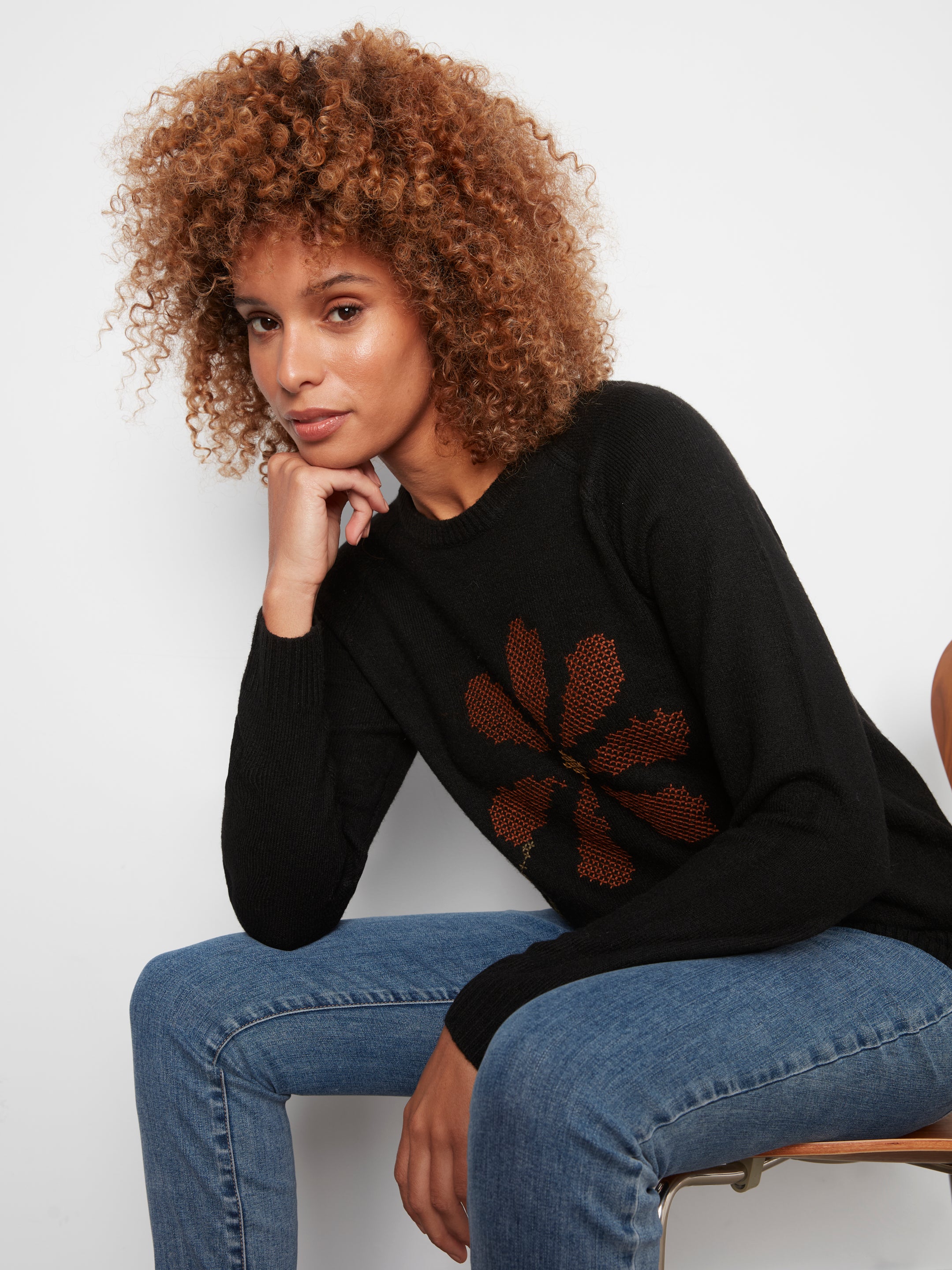 Pull noir à col rond et fleur brodée