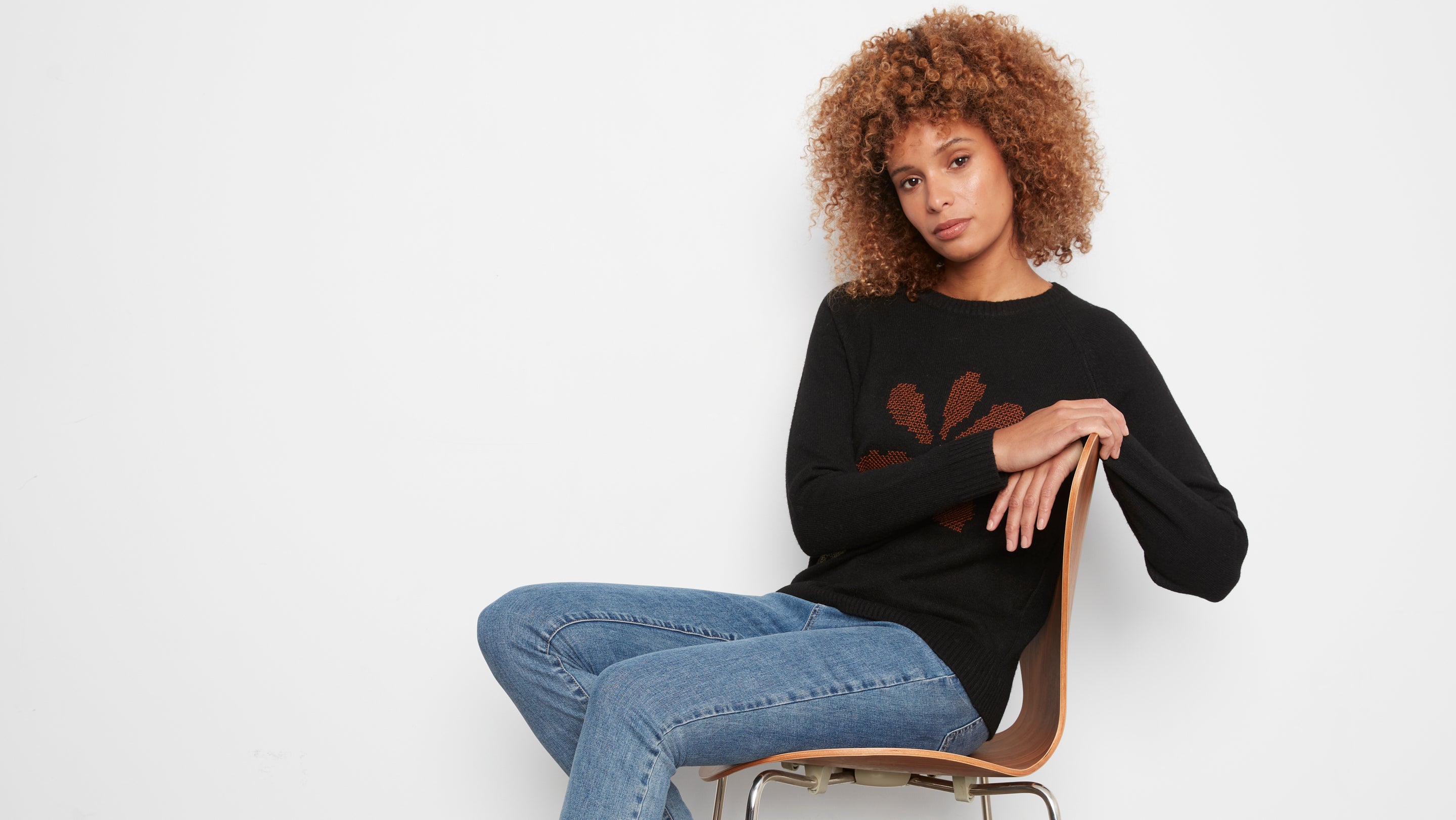 Pull noir à col rond et fleur brodée